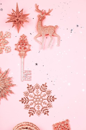 Golden beautiful sparkling christmas decorative toys on pastel pink background. Place for text. Vertical photo.の写真素材