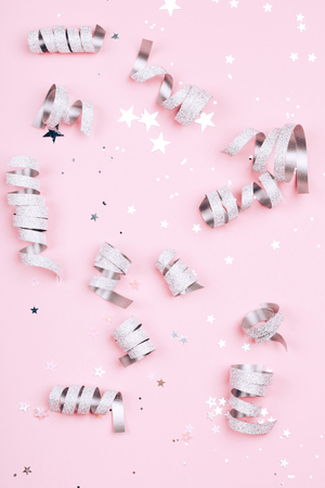 Silver sparkles, stars and glitters on pink background. Festive concept.の写真素材