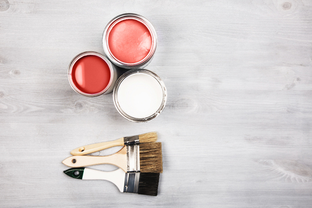 House renovation, paint cans and colored brushes on white wooden background. Living Coral Color of the year 2019.の写真素材