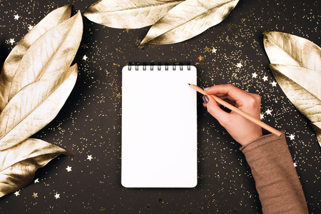 Goal lift for New Year. Holiday decorations and notebook with clean note book on dark table, flat lay style. Planning concept.の写真素材