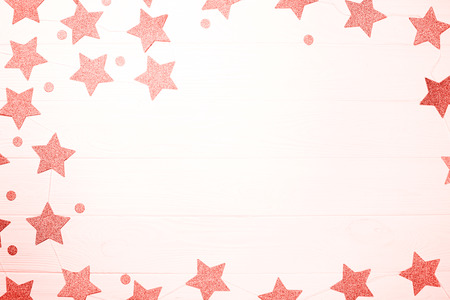 Golden decoration of stars and circles is creating frame on white wooden background. Place for text.の写真素材
