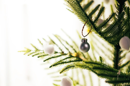 Fir branch with balls and festive lights on Christmas background with sparkles.