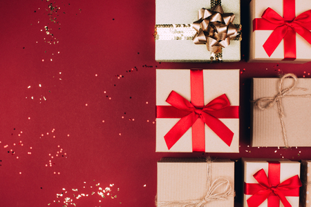 Many Christmas craft presents on red background with glitter. Festive concept. Top view.の写真素材