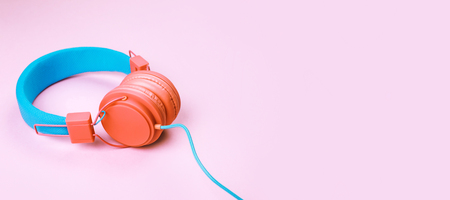 Banner made with Coral and blue headphones on pink background. Place for text on it. Concept of Color 2019.の写真素材