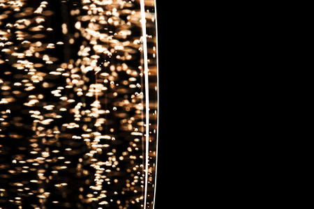 One glass of champagne isolated on black background. Macro, place for text. Festive concept.の写真素材