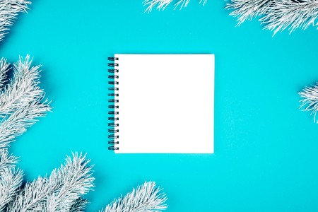 Note book with Wish List. Snowy fir branches on blue background. Christmas and winter concept.の写真素材