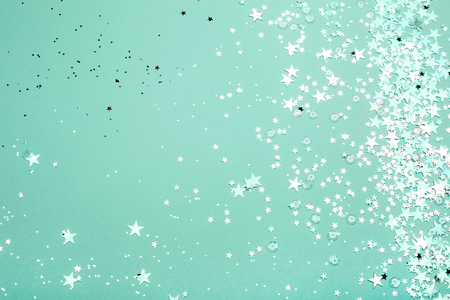 Silver and pink star glitter on teal pastel background. Festive concept. Place for design.の写真素材
