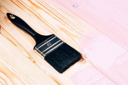 Open can of pink paint with white brush on painting wooden board. Renovation concept.の写真素材