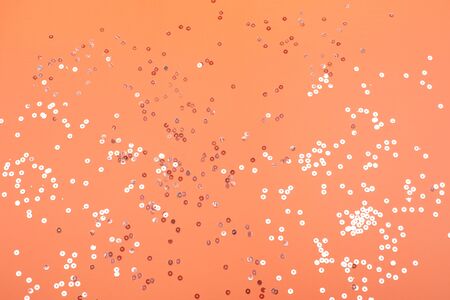Silver flying round confetti on trendy coral background. Festive backdrop for your projects.の写真素材