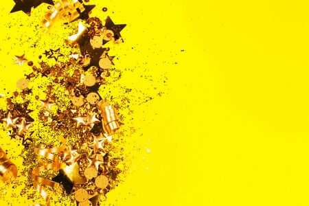 Golden sparkles on yellow background. Holiday concept.の写真素材