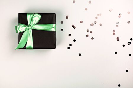 Black gift box with mint bow on white background with glitter. Holiday concept.の写真素材