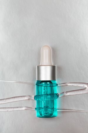 Bottle with hyaluronic acid on silver background. Concept of modern beauty. Flat lay style.の写真素材
