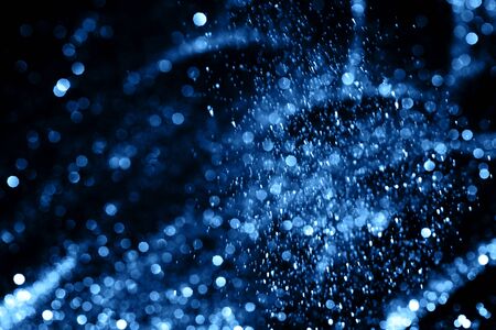 Splash of blue sparkles on black background. Color of the year 2020 concept.の写真素材