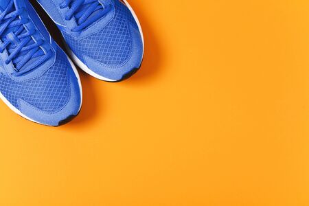 Blue sneakers on orange background. Concept of healthy lifestileの写真素材