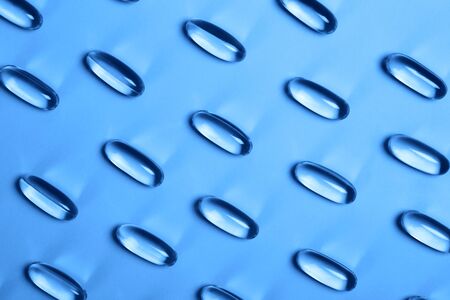 Capsules with oils for beauty. Concept of modern health-care. Flat lay style. Blue colorの写真素材