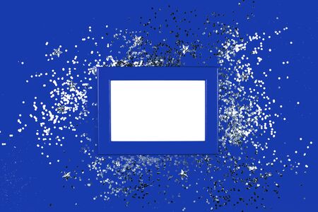 Frame on blue background with silver sparkles. Flat lay style. Trendy color.の写真素材