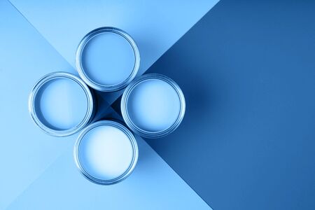 Four open cans of paint on bright symmetry background.Blue color. Place for text. Renovation concept.の写真素材
