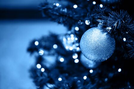 Fir branch with balls and festive lights on the Christmas background with sparkles.の写真素材