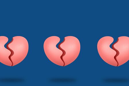 Three coral broken hearts on blue background. Concept of changing color of the yearの写真素材