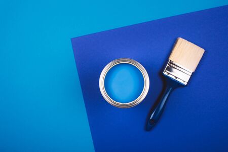 Brush on open can of blue paint on blue background. Color of the year in interior.の写真素材