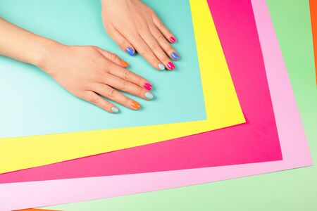 Neon manicure on different multicolored neon backgrounds. Flat lay style.の写真素材
