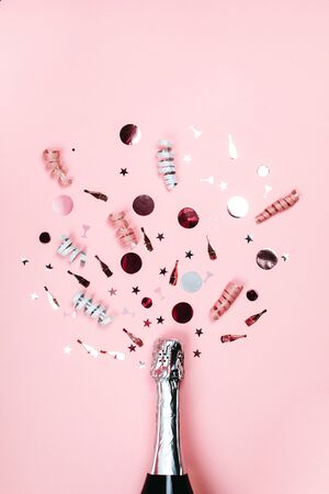 Bottle of champagne with splash of confetti. Flat lay style.の写真素材