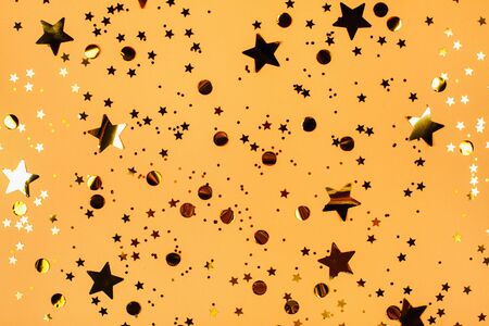 Falling golden stars glitter on pink background. Festive holiday pastel backdrop.の写真素材