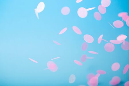Orange and yellow falling confetti on blue backgroundの写真素材