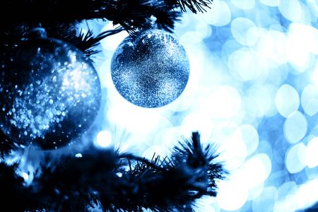 Fir branch with balls and festive lights on the Christmas background with sparkles.の写真素材