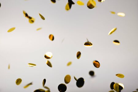 Golden falling confetti on grey background. Holiday concept.の写真素材