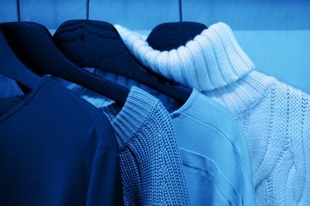 Colorful knitwear warm cloth on black hangers. Fashion concept.の写真素材