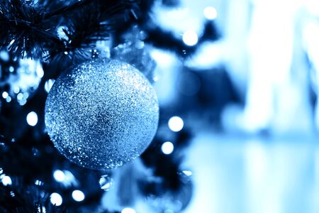 Fir branch with balls and festive lights on the Christmas background with sparkles.の写真素材