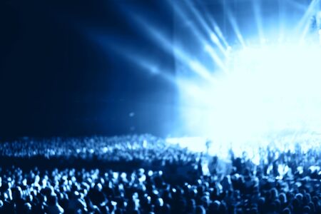 Blurred people crowd at musical concert and stage smoke. Defocused background.の写真素材