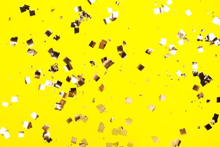 Falling silver confetti on yellow backdrop. Holiday concept.の写真素材
