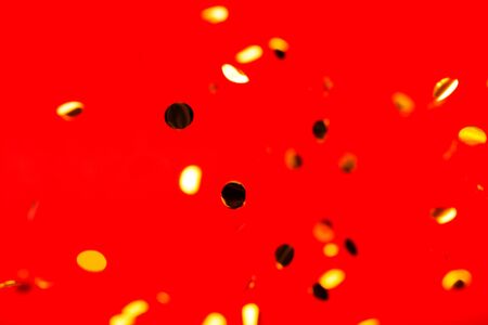 Golden falling confetti on red background. Holiday concept.の写真素材