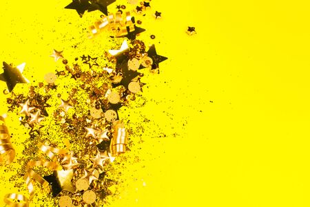 Golden sparkles on yellow background. Holiday concept.の写真素材