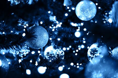 Fir branch with balls and festive lights on the Christmas background with sparkles.の写真素材