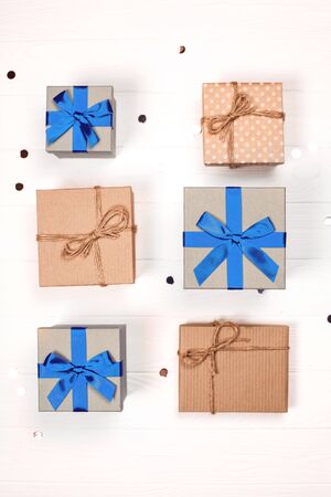 Neat rows of six christmas craft gift boxes with glitter on white wooden background. Flat lay. Festive concept.の写真素材