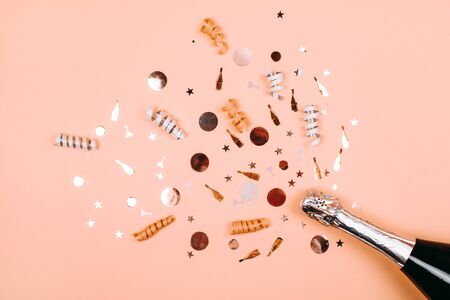 Bottle of champagne with splash of confetti. Flat lay style.の写真素材