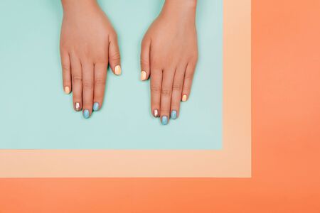 Manicure in trendy colors: coral, metallic yellow and mint on colorful background. Flat lay style.の写真素材
