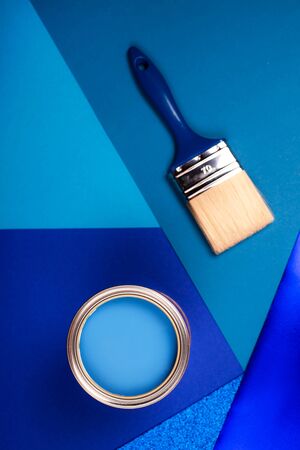 Brush on open can of blue paint on blue background. Color of the year in interior.の写真素材