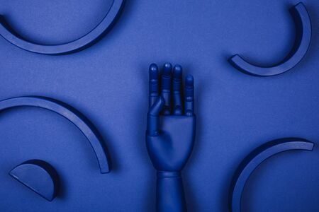 Blue hand with abstract 3d forms. Concept of demonstrating color of the year.の写真素材