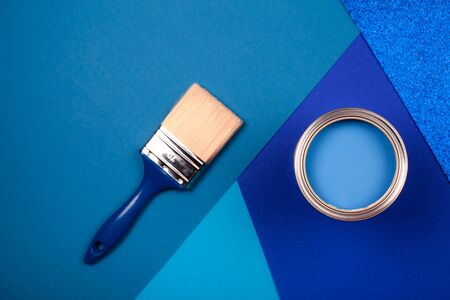 Brush on open can of blue paint on blue background. Color of the year in interior.の写真素材