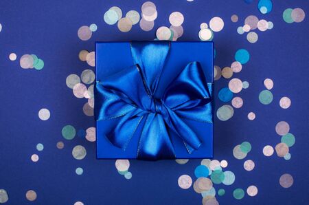 Blue present box with bow in monochrome trendy flat lay composition with confettiの写真素材