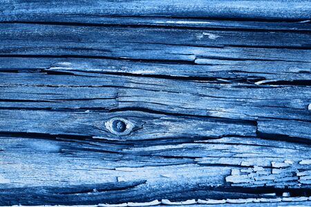 Old wood texture with deep cracks and peeling blue paintの写真素材