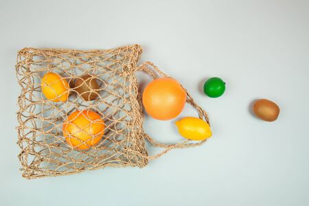 Fruits on textile bag. Trendy green background. Zero waste concept. Flat lay style.の写真素材