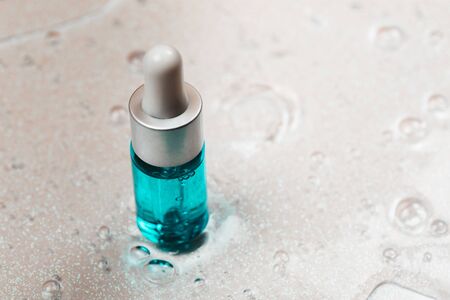 Bottle of hyaluronic acid on background with oxygen bubbles.