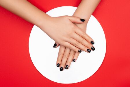 Black manicure on creative red and silver background. Flat lay style.の写真素材