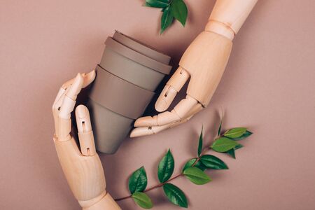 Wooden hand holding reusable cup of coffee. Concept of plastic-free and zero waste livingの写真素材