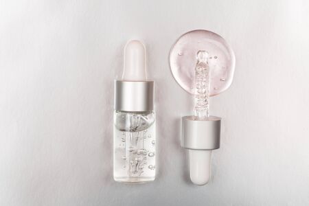 Bottle with hyaluronic acid on silver background. Concept of modern beauty. Flat lay style.の写真素材